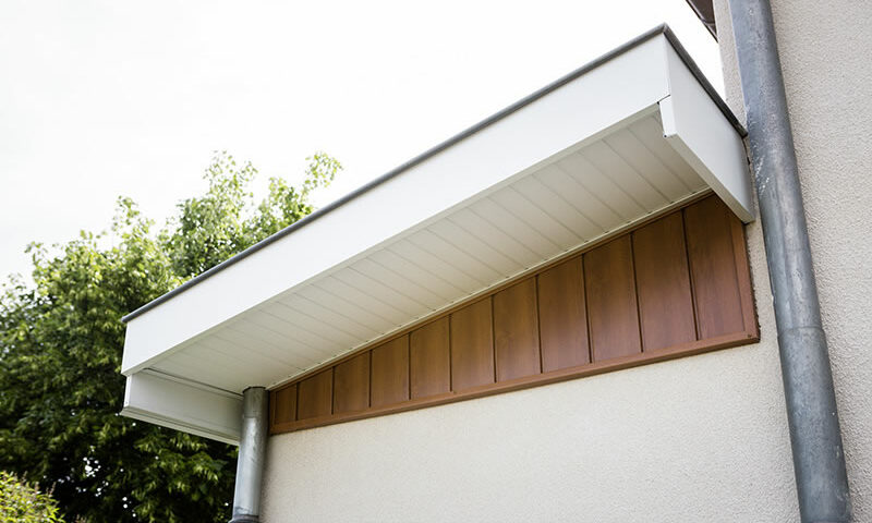 Habillage bandeaux et sous faces blanches et bardage aluminium marron sur le mur de cette maison réalisés par Bourguignon Dal'Alu